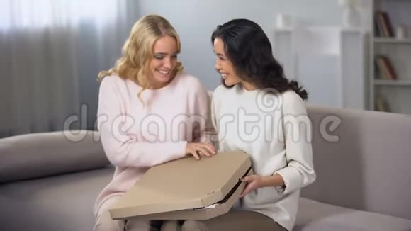 两个女人在家玩打开披萨盒送食物家庭聚会视频的预览图