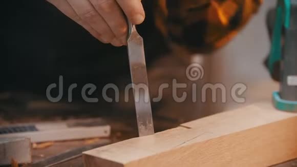 木工一名木工用凿子凿出木块上的凹槽视频的预览图