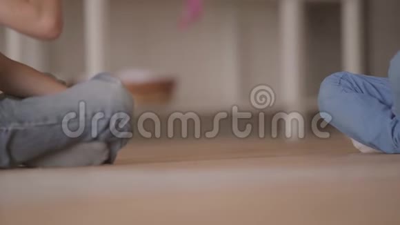 两个不认识的小男孩坐在地板上玩玩具汽车坐在地板上在家里兄弟姐妹视频的预览图