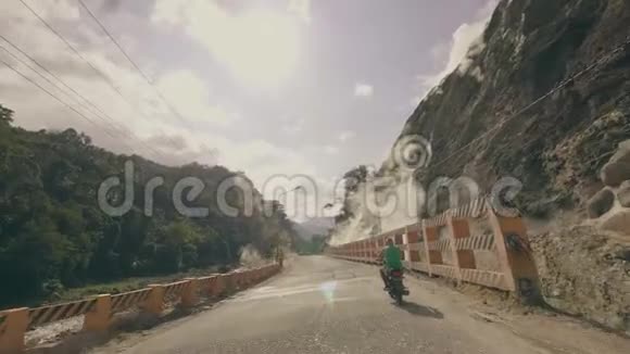 夏天旅行时骑摩托车经过温泉和高山骑摩托车的旅行者视频的预览图