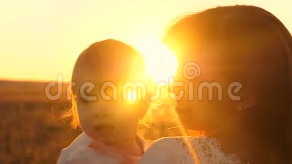 家人妈妈在公园吻小女儿快乐童年的概念妈妈带着一个小孩子看着一个美丽的视频的预览图