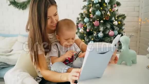 一位年轻的母亲和一个年轻的儿子在桌子旁看书视频的预览图