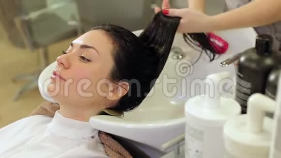 美发师给女孩的头发戴上保湿油面膜视频的预览图