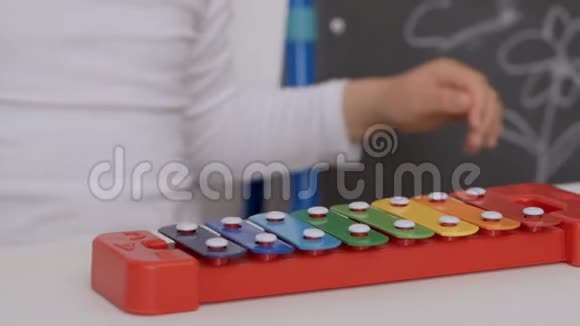 一个小女孩坐在孩子们房间桌子旁玩木琴视频的预览图