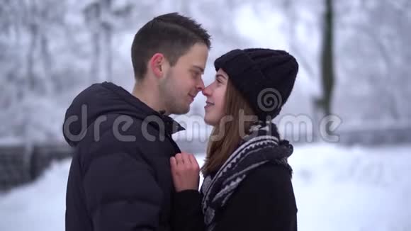冬天公园里白雪皑皑的可爱少女画像恋爱中快乐的一对享受在一起的时光冬季休闲视频的预览图