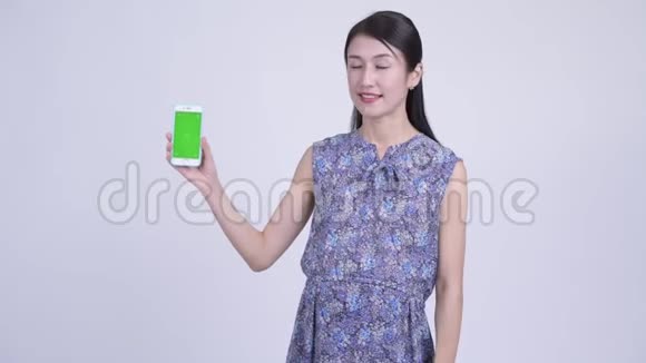 快乐怀孕的亚洲女人打电话竖起大拇指视频的预览图