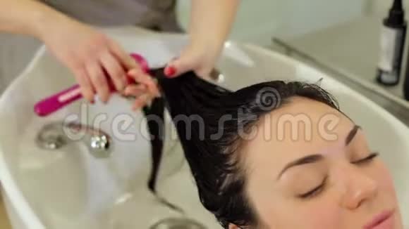 美发师给女孩的头发戴上保湿油面膜视频的预览图