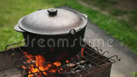 烧烤架上的火和盘子是用大的铸铁锅煮的视频的预览图