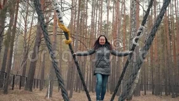 一个女人在城市公园的一个巨大的木制秋千上荡秋千视频的预览图