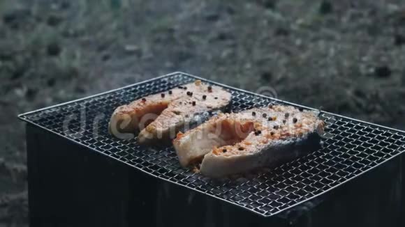 烤三文鱼烧烤用烤架上的叉子烤三文鱼牛排视频的预览图
