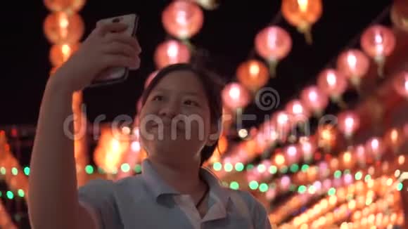 亚洲女人用智能手机自拍感到快乐漂亮的灯笼视频的预览图