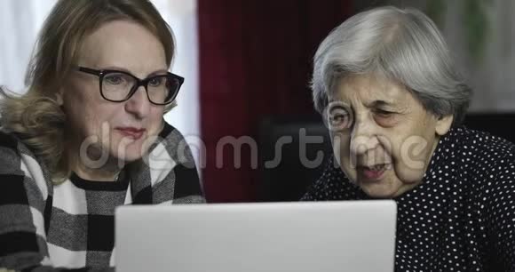 两名高级妇女通过互联网在电脑上交流视频的预览图