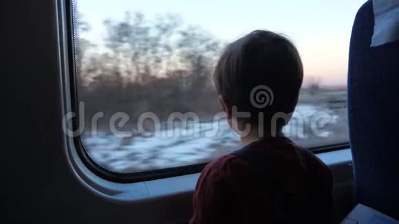 小男孩坐火车在窗外看旅行概念提前放假学龄前儿童视频的预览图