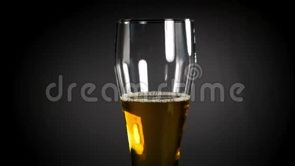在黑色背景上的玻璃杯里放冷光啤酒快来点手工啤酒4UHD视频视频的预览图