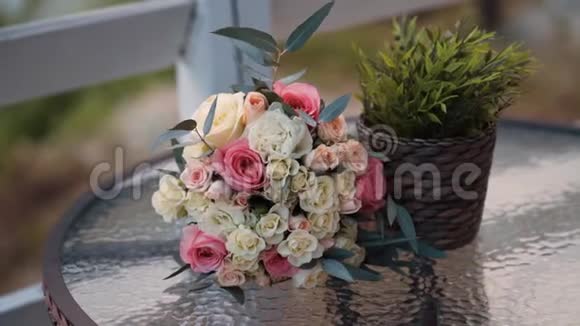 在玻璃圆桌上合上新娘的鲜花束视频的预览图