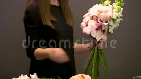 穿着黑色衣服的女人用不同的花做新的花束视频的预览图