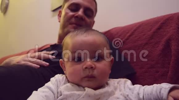 父亲正在模仿他六个月大的小男孩在挠脚痒的声音宝贝逗乐了视频的预览图