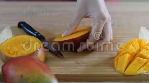 女厨师她的手在木切割板上切芒果夏季健康素食水果沙拉视频的预览图
