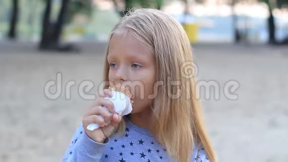公园里的小女孩吃冰淇淋蛋筒特写视频的预览图