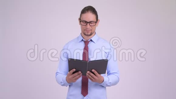 快乐英俊的商人带着眼镜看书思考视频的预览图