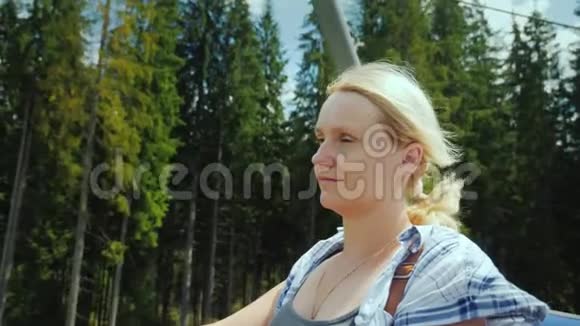 一个迷人的女人站在滑雪台上欣赏美丽的夏天景色视频的预览图