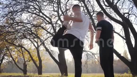 两个强壮的白人运动员在秋季公园热身成年帅哥在运动前伸展身体视频的预览图