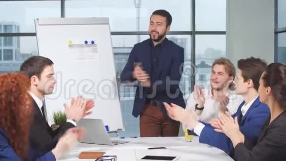 一群商人在办公室祝贺同事他们拍手微笑视频的预览图