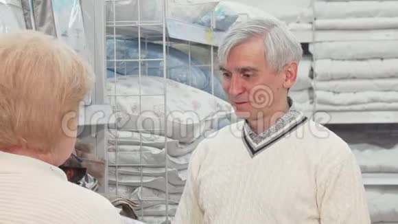 一位老人和妻子一起在家具店挑选床上用品视频的预览图