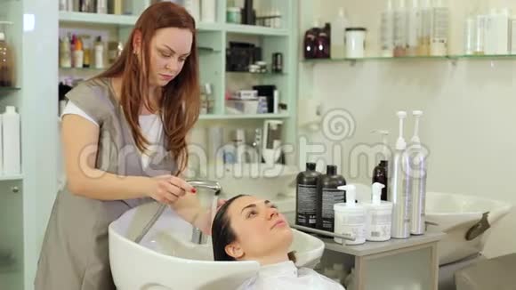 理发师在一家美容院给顾客洗头发视频的预览图