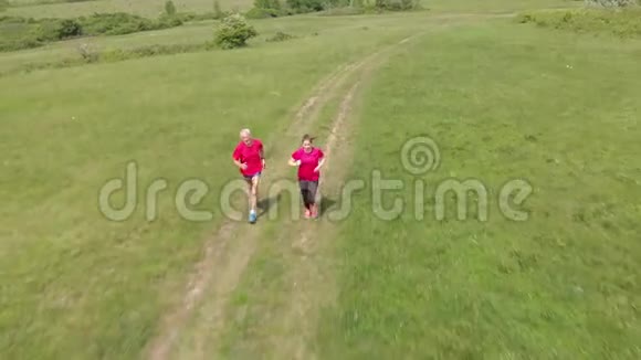 老人和他的孙子在草地上奔跑空中镜头视频的预览图