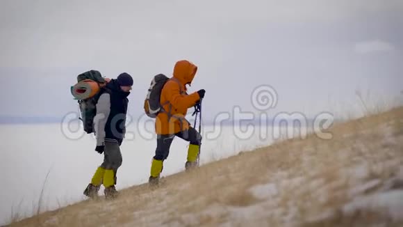 两个人在冬天的斜坡上慢慢地远足视频的预览图