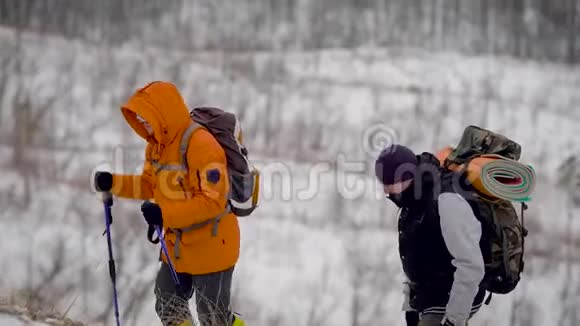 人们在草地和白雪覆盖的斜坡上远足视频的预览图