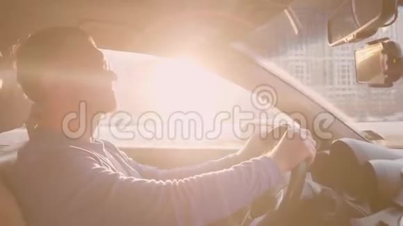 白人司机放慢速度让其他汽车通过人微笑继续开车日落的天空背光灯视频的预览图