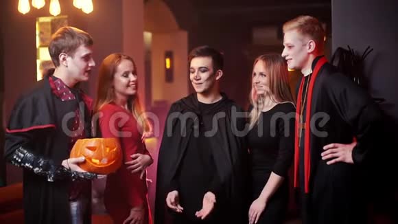 一群穿着五颜六色服装的年轻快乐的朋友正在庆祝万圣节视频的预览图