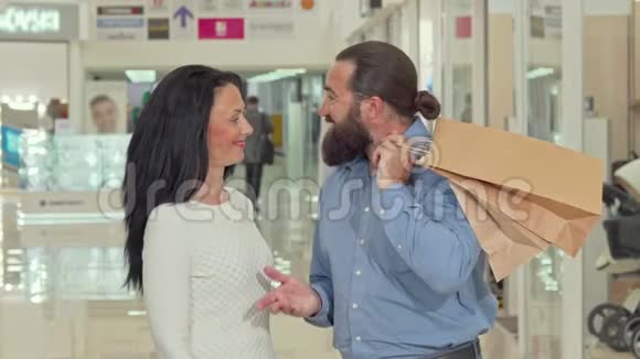 一个长着胡子的帅哥和他可爱的妻子正在里面寻找购物袋视频的预览图