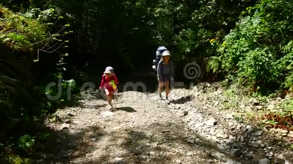 妈妈和孩子们带着背包在山上爬山视频的预览图