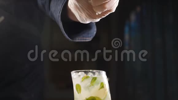 关闭手厨师挤压石灰新鲜莫吉托鸡尾酒的慢动作果汁从水果里流出来男性手视频的预览图