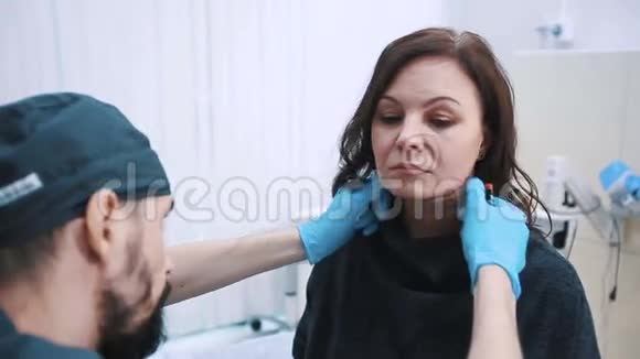 整容手术前整形外科医生检查中年妇女面部视频的预览图