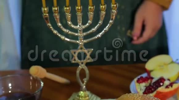 一位犹太妇女在节日聚会上点燃罗什哈沙纳的蜡烛享受时光视频的预览图