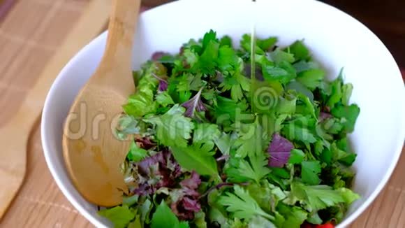 女厨师在纯素沙拉上倒入橄榄油视频的预览图
