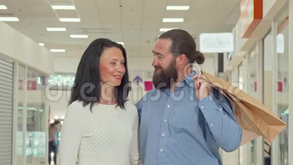 快乐的成熟夫妻享受当地购物中心的季节性销售视频的预览图
