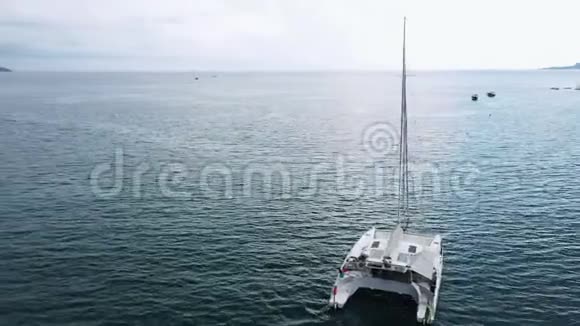 一艘停泊的双体游艇站在空中人们可以甲板上日光浴视频的预览图