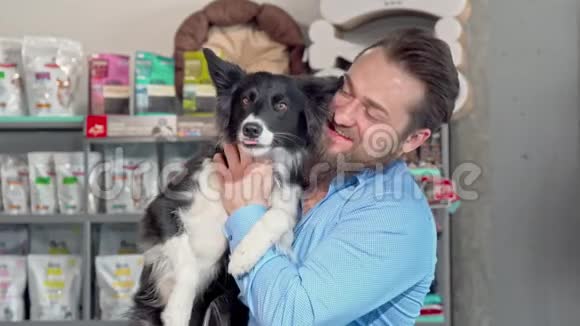 快乐的人抱着他可爱的狗对着镜头微笑视频的预览图