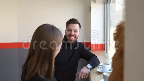 一对年轻夫妇在一家小咖啡店里休息喝着卡布奇诺视频的预览图
