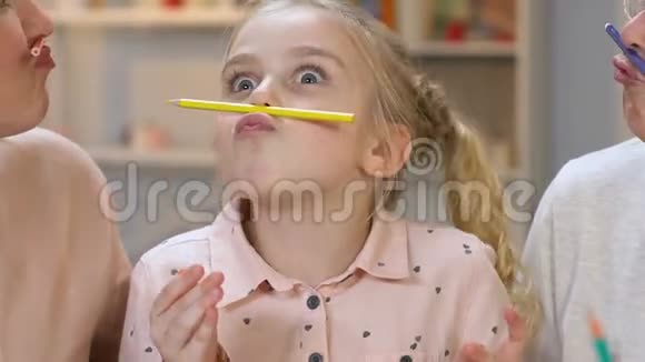 小女孩用铅笔做胡子和父母一起玩快乐视频的预览图
