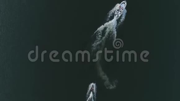 从上面可以看到的空中景色船上有人骑着船沿着河走手里拿着绳子系在摩托艇上留下白尾视频的预览图