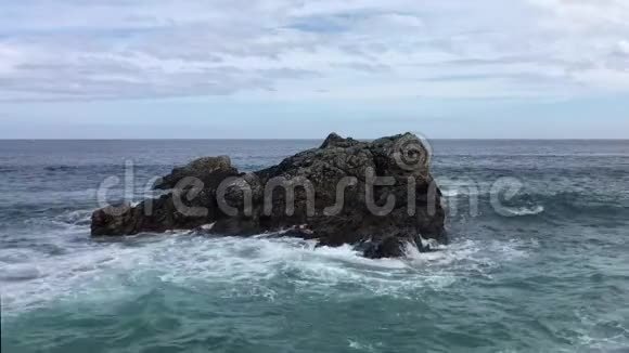 波浪在海中的黑色岩石上视频的预览图