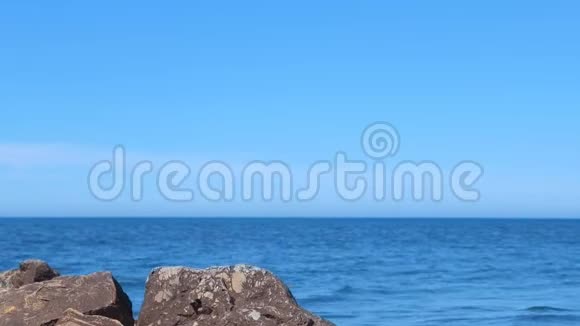 在阳光明媚的日子里海滨有着巨大的鹅卵石的风景海景视频的预览图