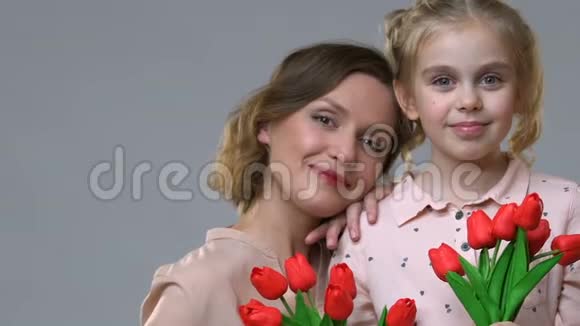 母亲和女儿手持郁金香女性气质和春天情绪的肖像视频的预览图