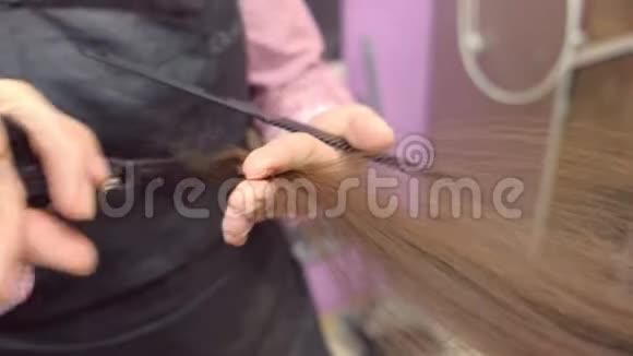 理发师用热剪剪子剪短头发双手特写视频的预览图
